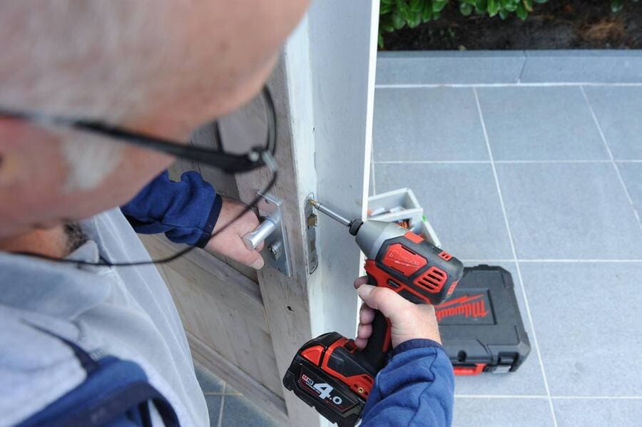 slotenmaker sleutelt aan deur